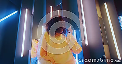 Grand angle positive africaine américaine noire femme en sweat à capuche jaune dansant dans la boîte de nuit rétro-éclairé avec vi banque de vidéos Grand angle positive africaine américaine noire femme en sweat à capuche jaune dansant dans la boîte de nuit rétro-éclairé avec vi banque de vidéos