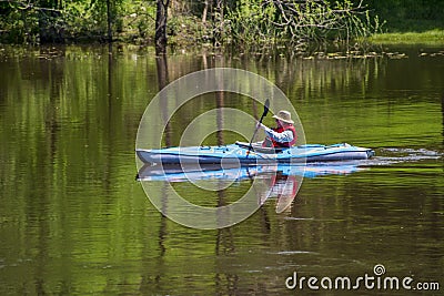 GRAND LEDGE, UNITED STATES - May 25, 2020: A women kayaker using an inflatable kayak on the Grand Rive Editorial Stock Photo