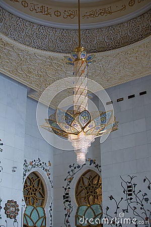 Grand Mosque large tall hallway of elegant glass colorful chandelier in center dome area in Abu Dhabi, United Arab Emirates Stock Photo