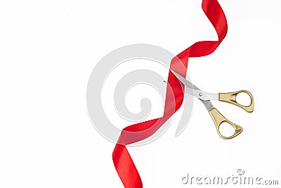 Grand opening. Top view of gold scissors cutting red ribbon on wite background. Stock Photo