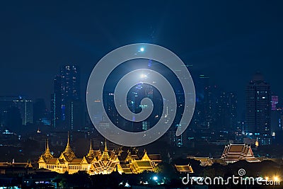 Grand palace bangkok with bangkok city skyscrapers at night in B Stock Photo