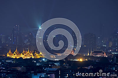 Grand palace with Bangkok city skyscrapers at night in Bangkok Stock Photo