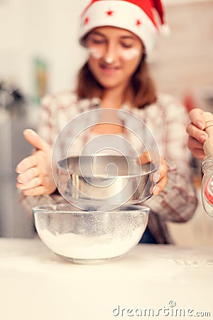 Grandchild on christmas day sifting flour for cookies Stock Photo