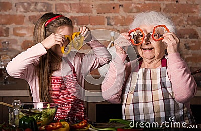 Grandchild with granny holding slices of pepper Stock Photo