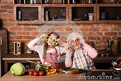 Grandchild with granny holding slices of pepper Stock Photo