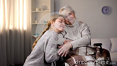 Granddaughter hugging handicapped grandmother, family kindness, volunteering Stock Photo