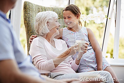 Granddaughter Visiting Grandparents In Lounge Of Retirement Home Stock Photo