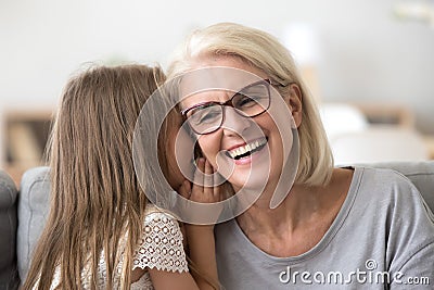 Granddaughter whisper something to granny sharing secret Stock Photo