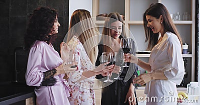 Grande grupo de sorriso de senhoras no pijamas que apreciam o partido da solteira em casa que bebe o vinho e que sente muito filme Grande grupo de sorriso de senhoras no pijamas que apreciam o partido da solteira em casa que bebe o vinho e que sente muito filme