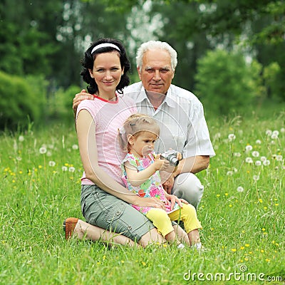 Grandfather, daughter and granddaughter are photographed outdoors. Stock Photo