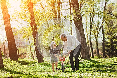 Grandfather with girl and bicycle Stock Photo