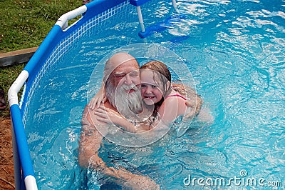 Grandfather and girl in pool Stock Photo