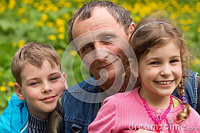 Grandfather, granddaughter and grandson smiling Stock Photo