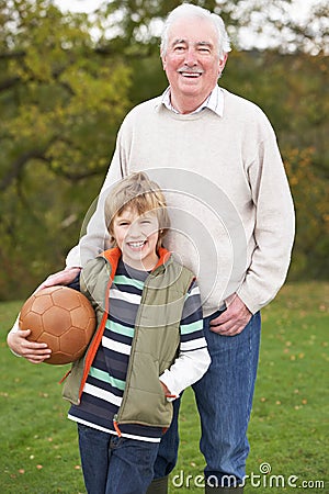 Grandfather With Grandson Holding Football Stock Photo