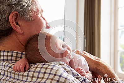 Grandfather Holding Sleeping Newborn Baby Granddaughter Stock Photo