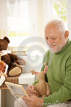 Grandfather looking at grandchild photo Stock Photo