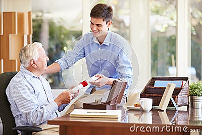 Grandfather Showing Document To Teenage Grandson Stock Photo