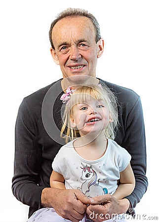 Grandfather sitting smiling and holding his small granddaughter on his knees solated on a white background Stock Photo