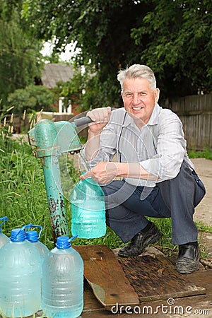 Grandfather takes water to bottle Stock Photo