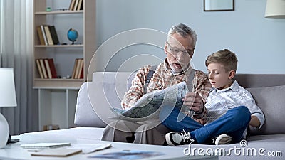 Grandfather veteran viewing map with grandson showing front line remembering war Stock Photo