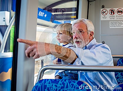 A Grandfather Spends Quality Time with His Grandson on a Rail Train Stock Photo