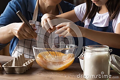 Grandkid helping grandma to cook omelet for breakfast Stock Photo