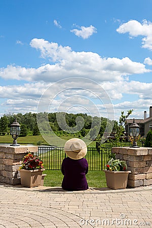 Grandma gardener taking a break to admire the view Stock Photo