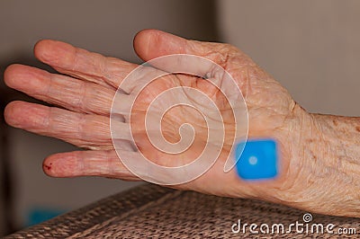 Grandma rolls a blue dice.Social game. Throwing a blue cube Stock Photo