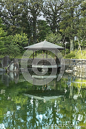 Grandmother came back for the obon festival that honors the spirits of the ancestors. She admires the pond by remembering the pas Stock Photo