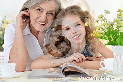 Grandmother with girl reading magazine Stock Photo