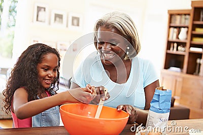 Grandmother And Granddaughter Baking Together At Home Stock Photo