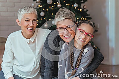 Grandmother and granddaughter decorating a Christmas treeFamily gathered around a Christmas tree, female generations Stock Photo