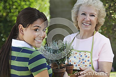 Grandmother And Granddaughter Holding Potted Plants Stock Photo