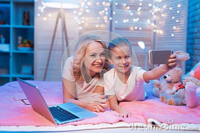 Grandmother and granddaughter are taking selfie at night at home. Stock Photo