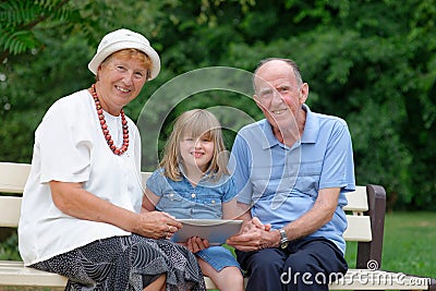 Grandmother, grandfather and granddaughter using tablet Stock Photo