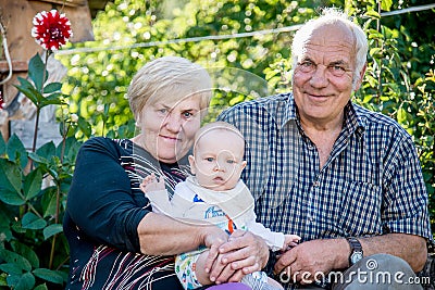 Grandmother and Grandfather holding their little boy Stock Photo