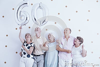 Grandmother and grandfather with silver balloons celebrating 60th birthday Stock Photo