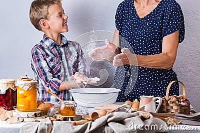 Grandmother with grandson cooking, kneading dough, baking in the kitchen Stock Photo