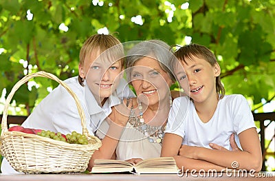 Grandmother and grandsons sitting at table Stock Photo