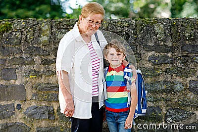 Grandmother taking child, kid boy to school on his first day Stock Photo
