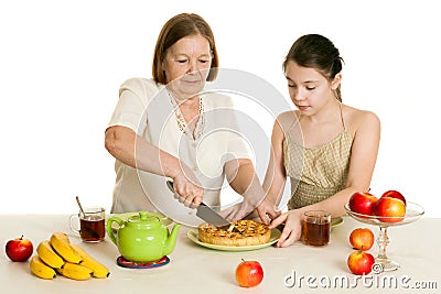 The grandmother treats the granddaughter with pie Stock Photo