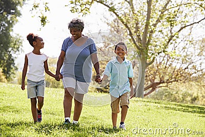 Grandmother Walking In Park And Holding Hands With Grandchildren Stock Photo