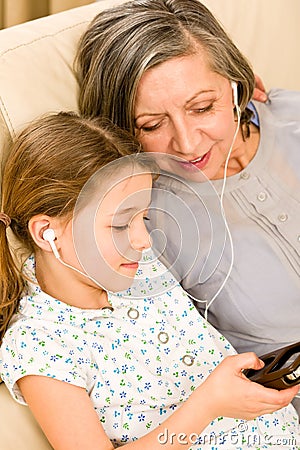 Grandmother and young girl listen music together Stock Photo