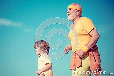 Grandpa and child sportsmen jogging outdoors and enjoying sunny day. Like sports. Funny sporty old sportsman and cute Stock Photo