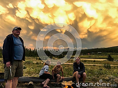 Grandpa with Grandchildren Looking at Stunning Stormy Sunset Clouds Editorial Stock Photo