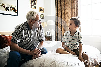 Grandpa and grandson sitting on the bed Stock Photo