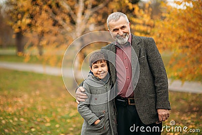 Grandpa and his grandson are walking in the park. The spend time together Stock Photo
