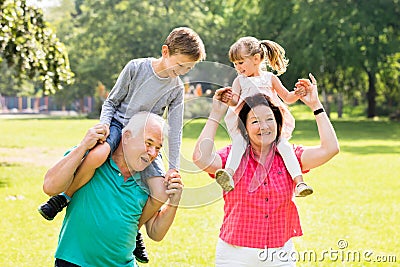 Grandparents Giving Grandchildren Piggyback Ride Stock Photo