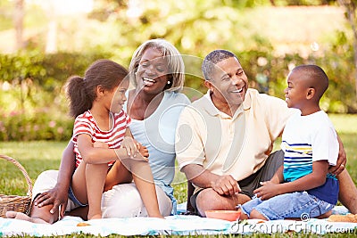 Grandparents And Grandchildren Having Picnic In Garden Stock Photo