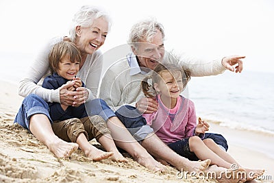 Grandparents And Grandchildren Sitting On Beach Together Stock Photo